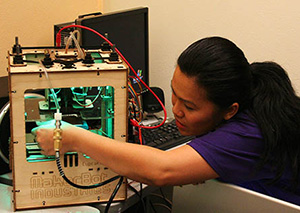 HCDE senior Darivanh Vlachos works with a 3-D Makerbot printer in Professor Beth Kolko's Design for Digital Inclusion Lab.