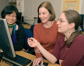 Jan with two students around a computer