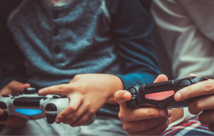 Close up on two hands playing video games with controllers