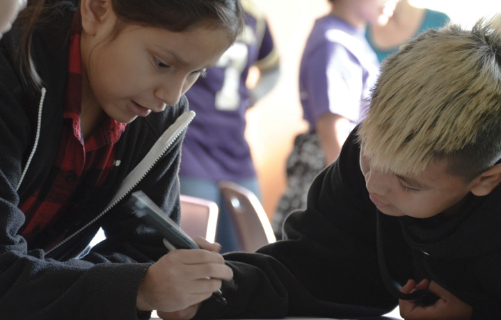 Two young students writing at a charette