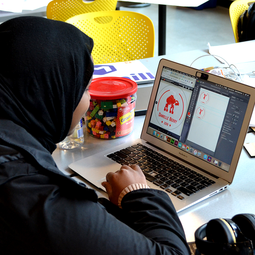 Student working on a computer with the Atari Women icons