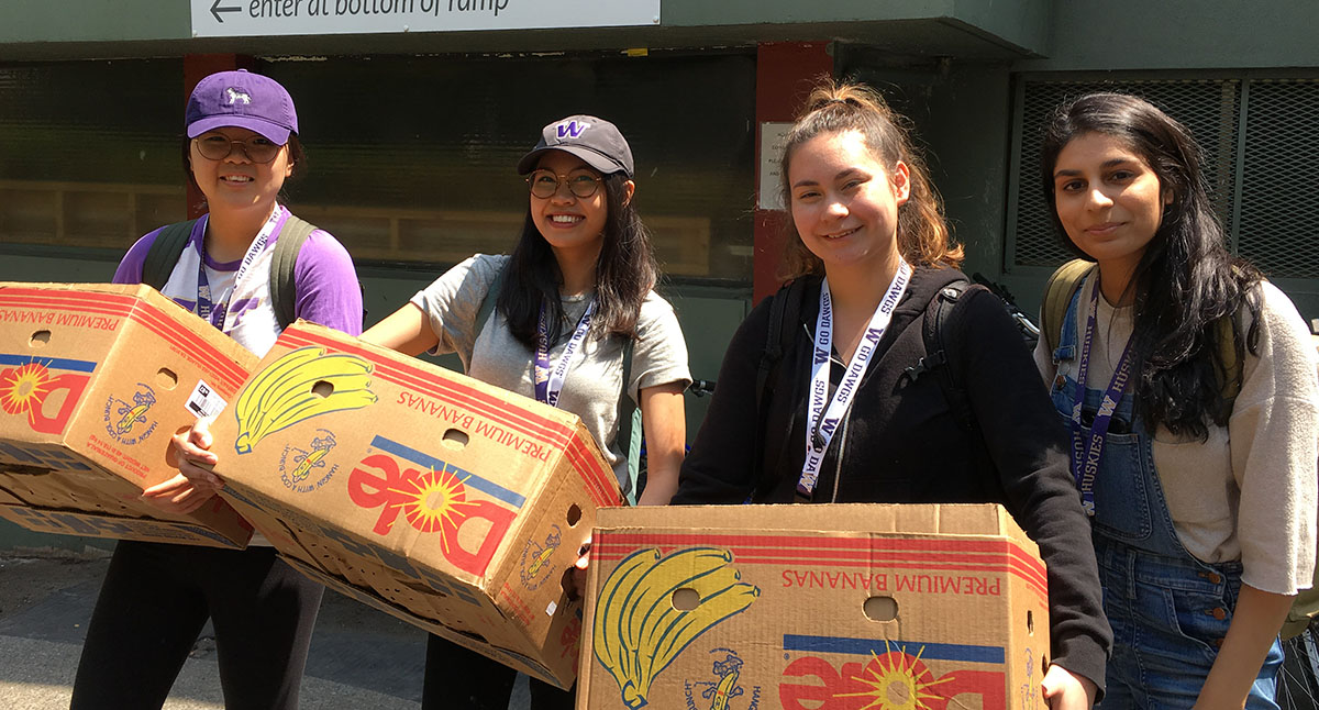 4 students carrying boxes of food to be delivered