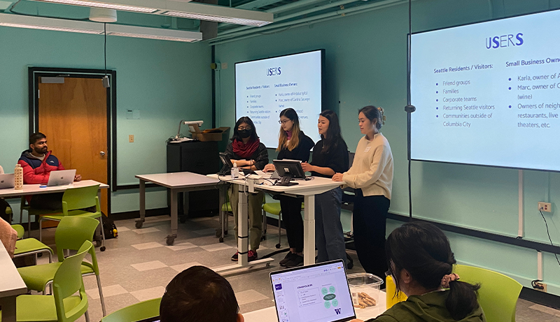 students presenting in front of HCDE classroom after a design jam