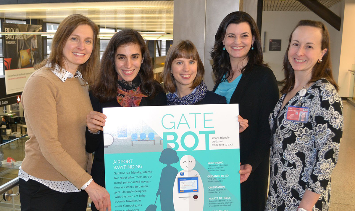 Four capstone students pose with their poster about a 