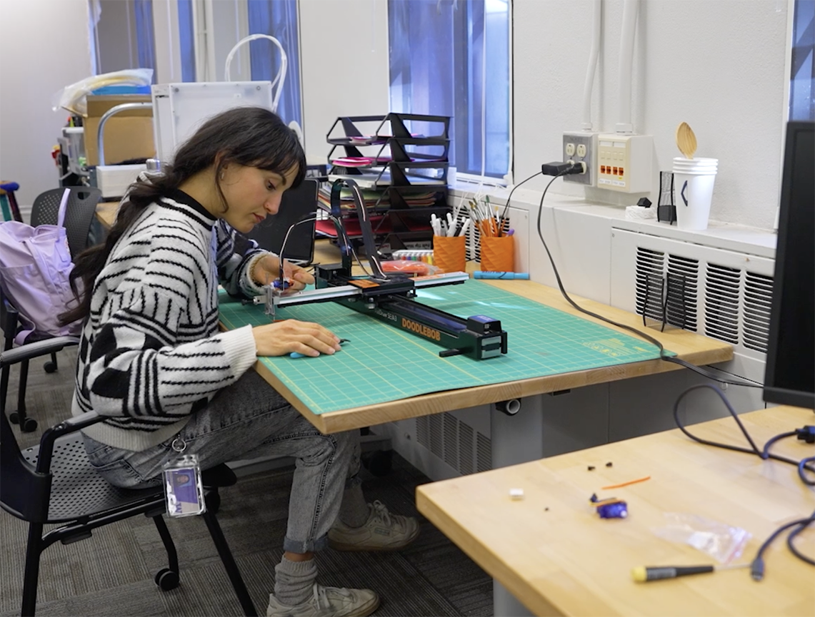 Student works over a table in HCDE's Machine Agency lab
