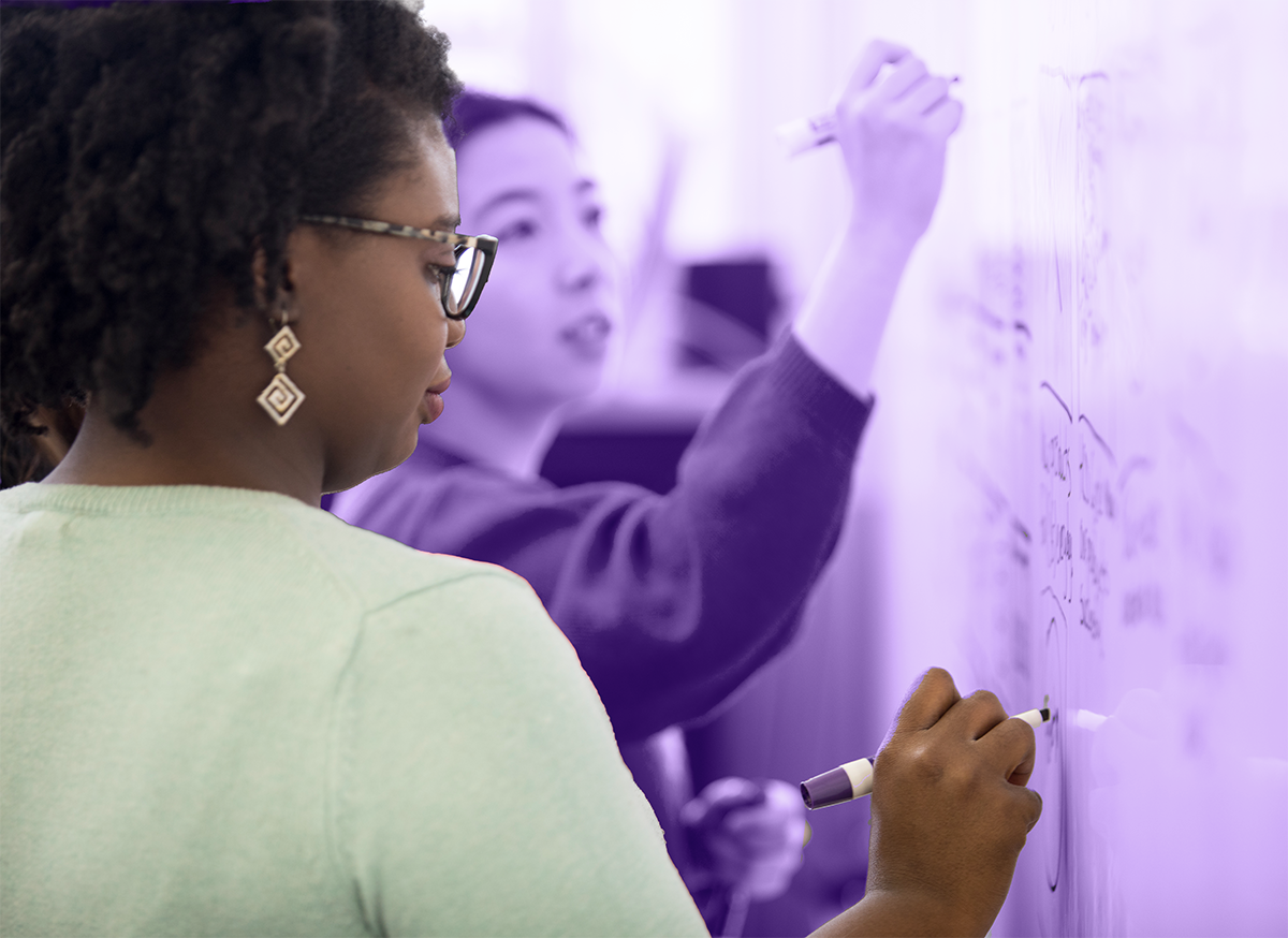 A student writing on a whiteboard