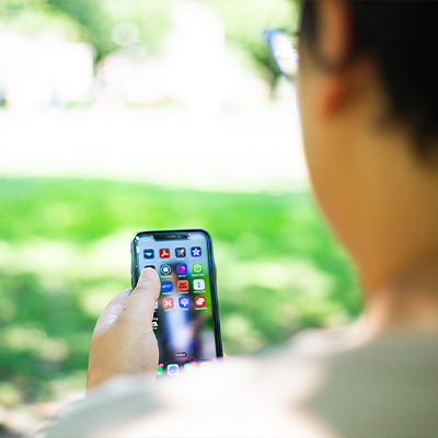 person using a cell phone sitting outside