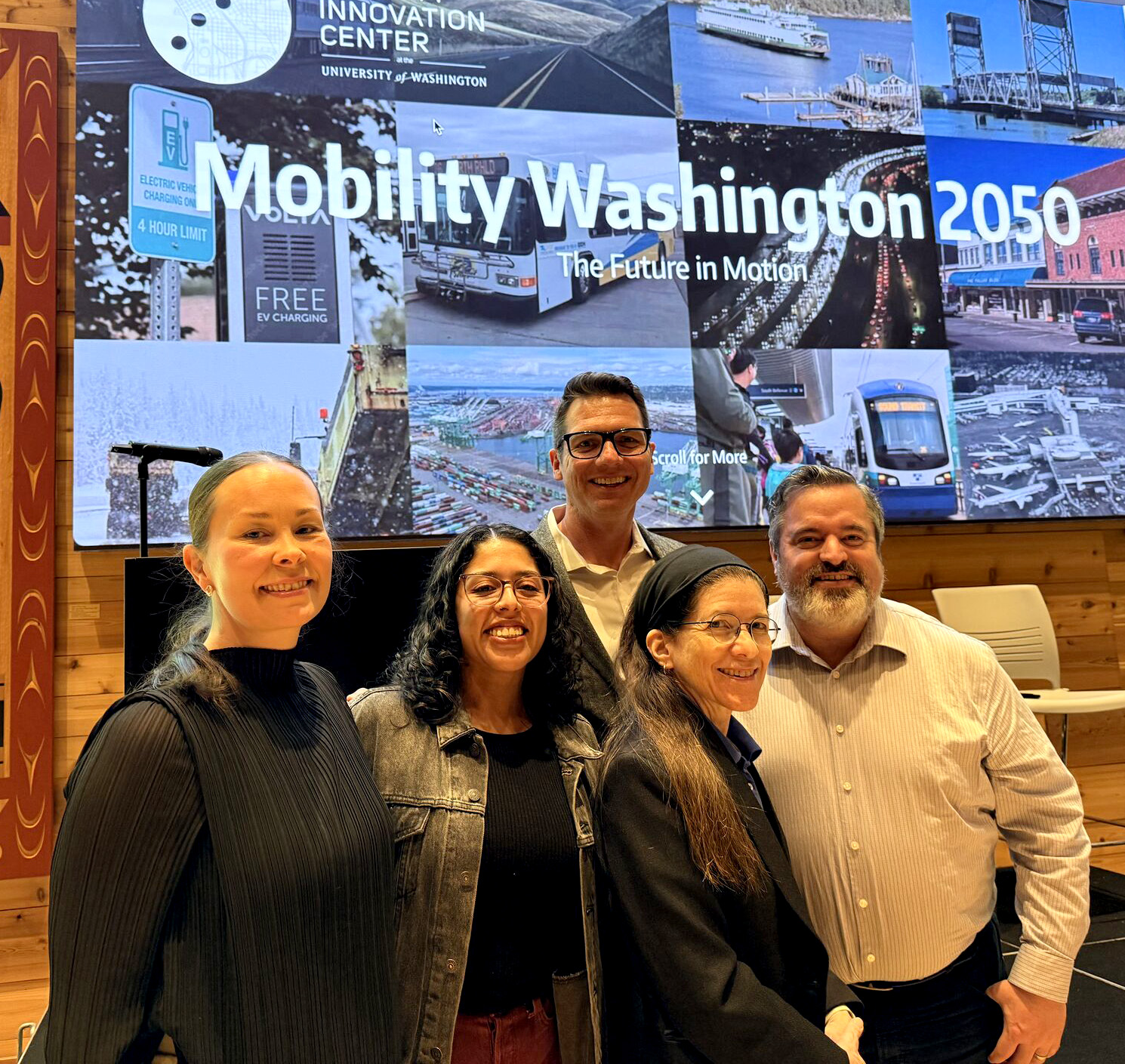 Five project leads stand in front of Mobility Washington 2050 sign