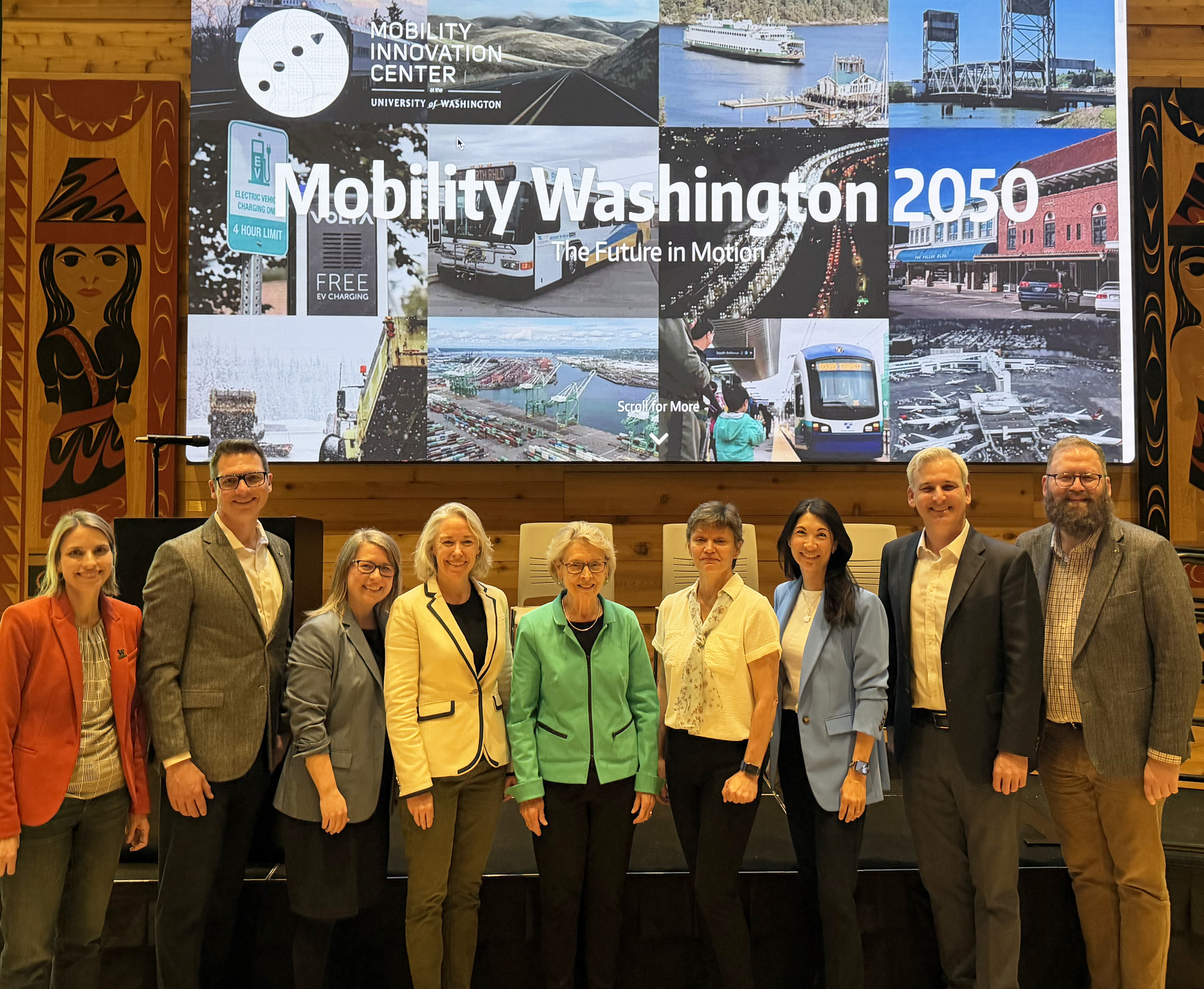 Group of leaders stand side-by-side in front of Mobility Washington 2050 sign