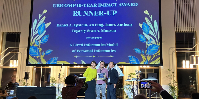 Daniel Epstein stands on stage accepting award at UbiComp 2025