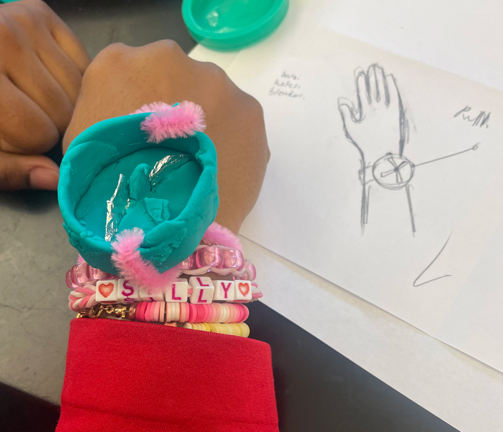 close up of watch prototype on a young students hand made out of play dough
