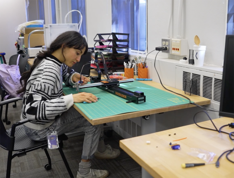Student works over a table in HCDE's Machine Agency lab