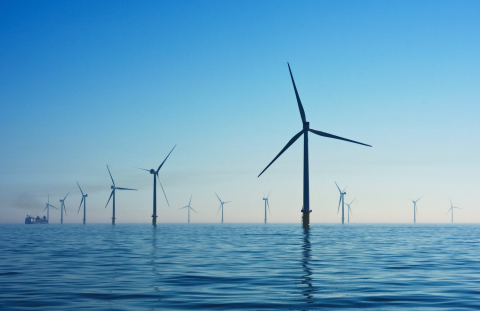 A dozen wind turbines in large body of water