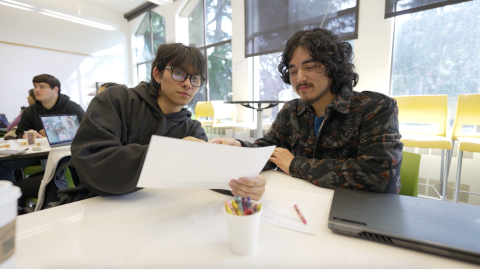 Two students reviewing work on paper in the HCDE Design Lab