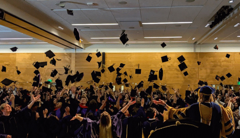 Graduates toss their caps in the air