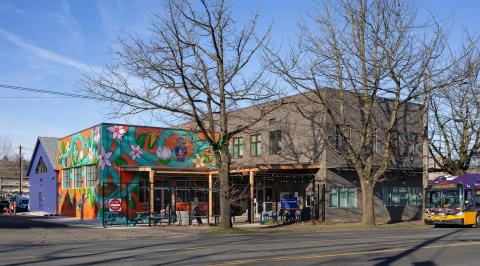Exterior of Rainier Valley Food Bank's community hub in Seattle's Rainier Beach neighborhood, featuring a colorful mural along Rainier Avenue South.