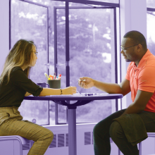 Two students seated in an HCDE classroom with purple effect on the image