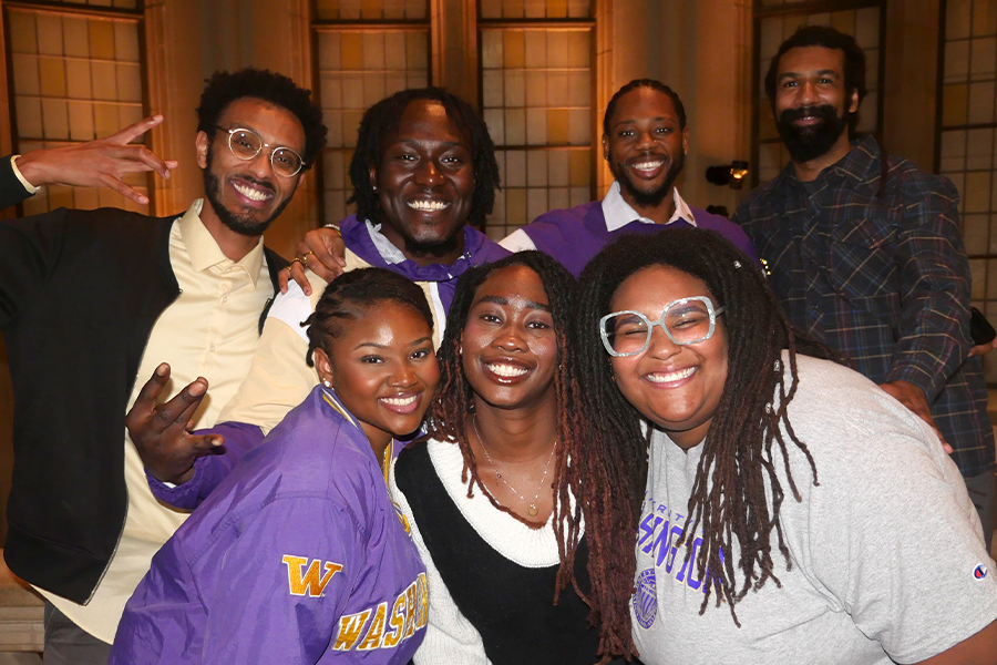Seven Black HCDE PhD students smiling for a group photo in UW's Suzallo Library