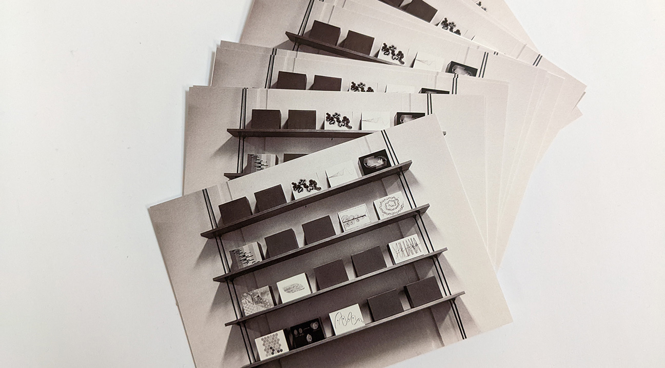 postcards advertising the dear design exhibition, displayed on a table