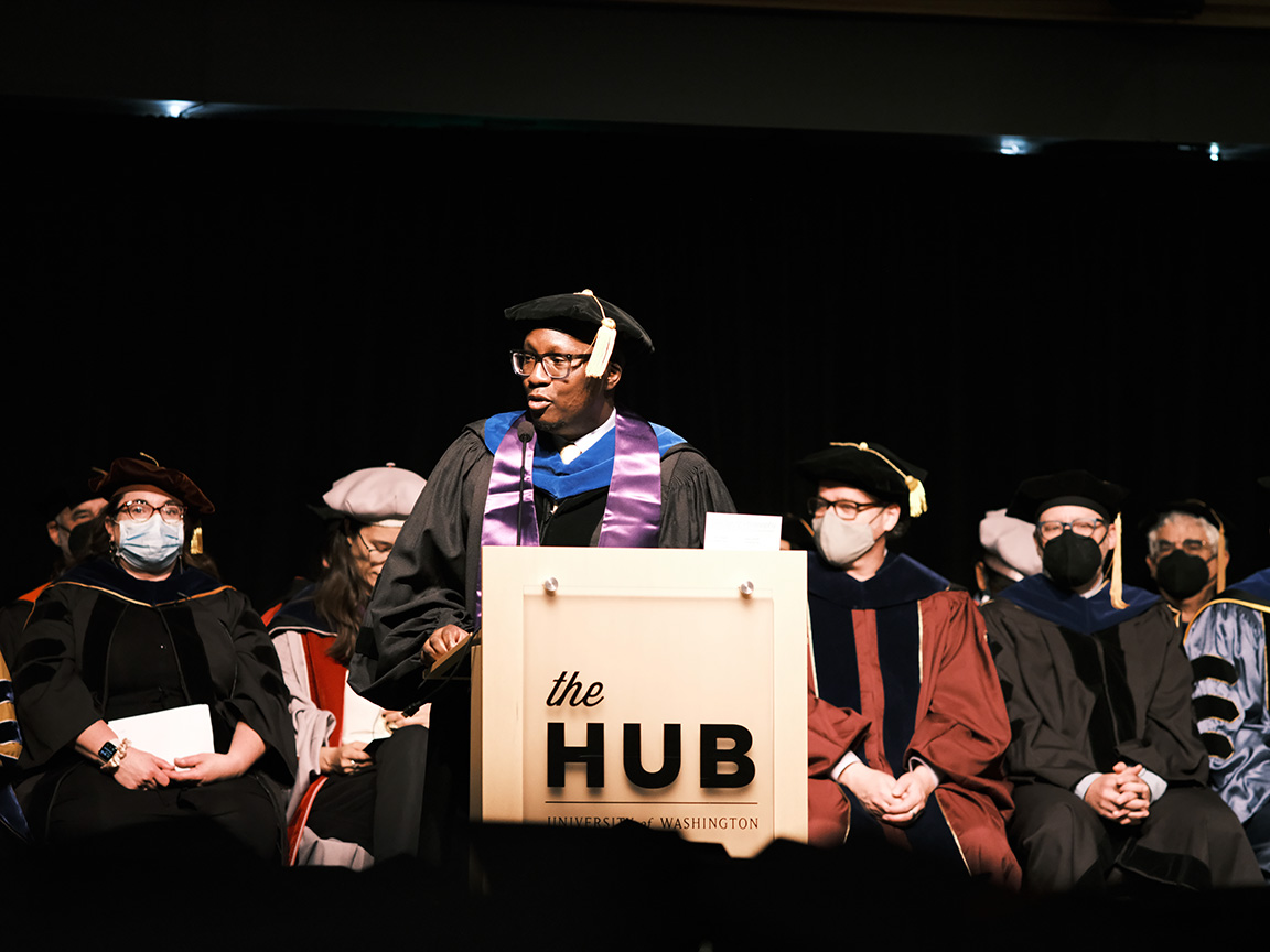 Dr. Onafuwa on the stage with HCDE faculty behind him