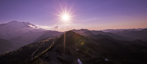 Mt Rainier with purple sky and bright sun