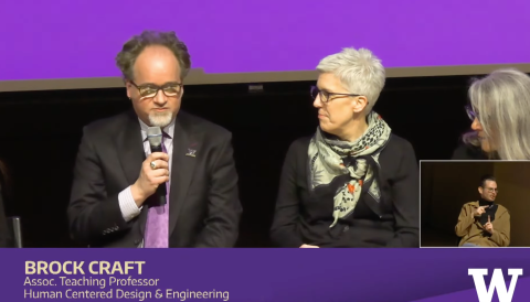 Brock Craft seated on stage with a microphone speaking during the panel