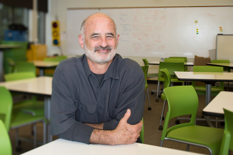 Andy Davidson seated at a whiteboard table in the HCDE Design Lab classroom